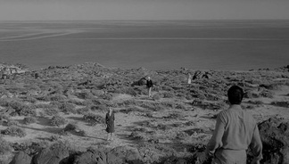 Still of a rocky landscape with people scattered across it from Antonioni’s L’avventura