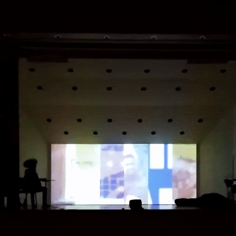 A flickering image is projected on the back wall of a concert stage.